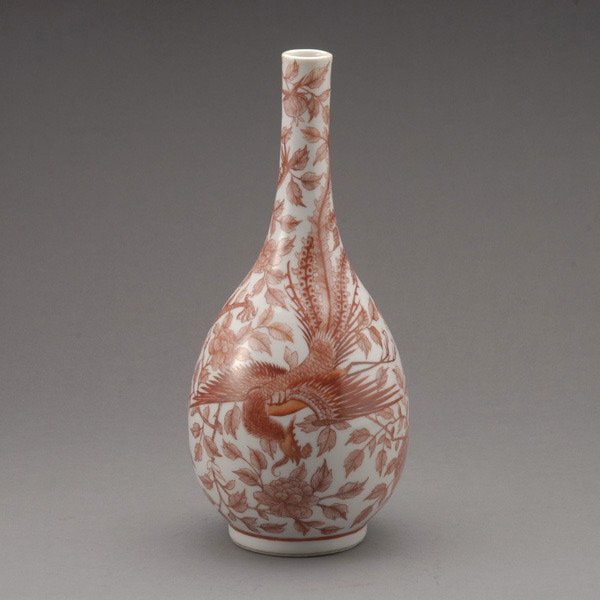 An Iron-Red Decorated Vase, Qianlong Mark: An Iron-Red Decorated Vase, Qianlong Mark, of elegant pear shape tapering to a cylindrical neck and rolled rim decorated with a five-clawed dragon along with a majestic phoenix on a bed of peony bloss