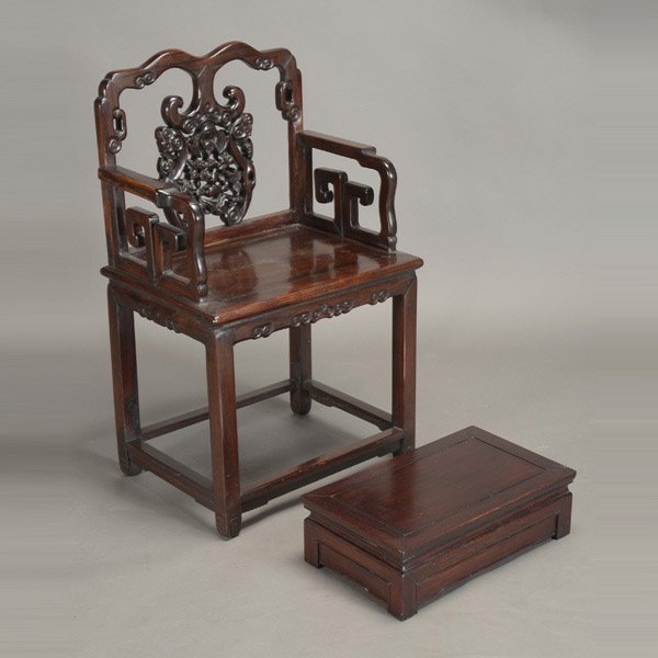 A Carved Hardwood Armchair and a Footrest: A Carved Hardwood Armchair and a Footrest, the chair decorated with a bat and double gourd flanked by ruyi scepters; the footrest originally a small side table now shortened {38 1/2 x 24 x 17 1/2 inch