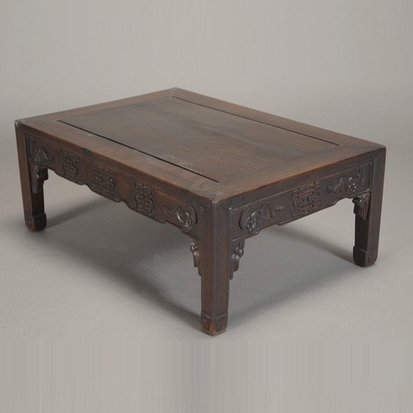 A Carved Hardwood Low Table: A Carved Hardwood Low Table, the recessed stepped aprons further carved with double-happiness characters and bats above spandrels depicting tassels, raised upon feet terminating in scroll decorations 