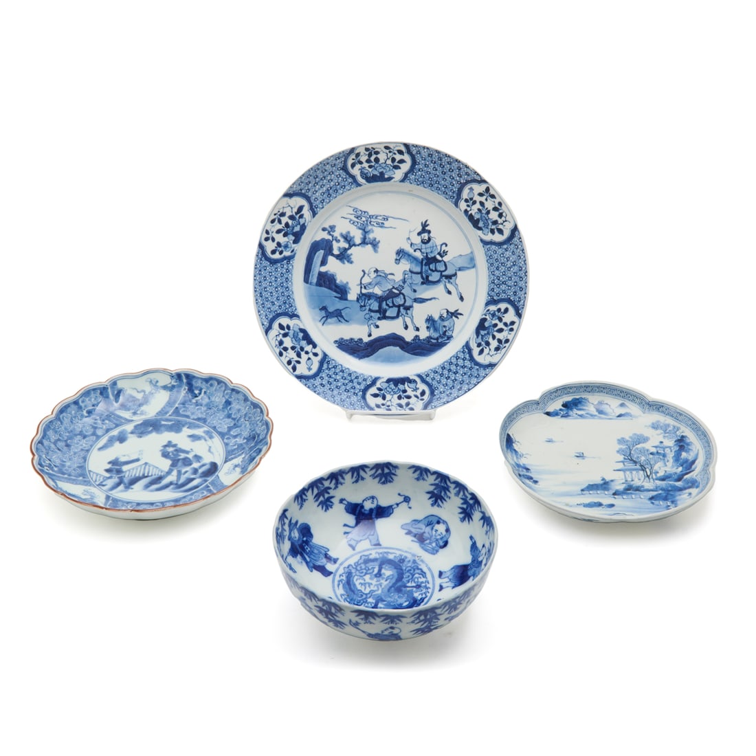 Japanese Arita Blue and White Porcelain Dinnerware: Japanese Arita Blue and White Porcelain Bowls and Plates. Comprising: first is a blue and white plate with a hunting scene, second two foliated plates one with a seaside landscape and the other showin