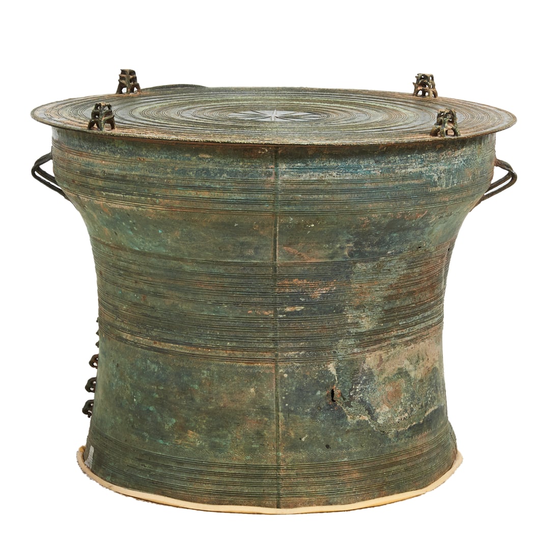 A Laotian Bronze Patinated Rain Drum: A Laotian Bronze Patinated Rain Drum. Of flared circular form, the top surmounted by four animal form finials encircling concentric geometric patterns, the geometric patterns repeated on the curving e