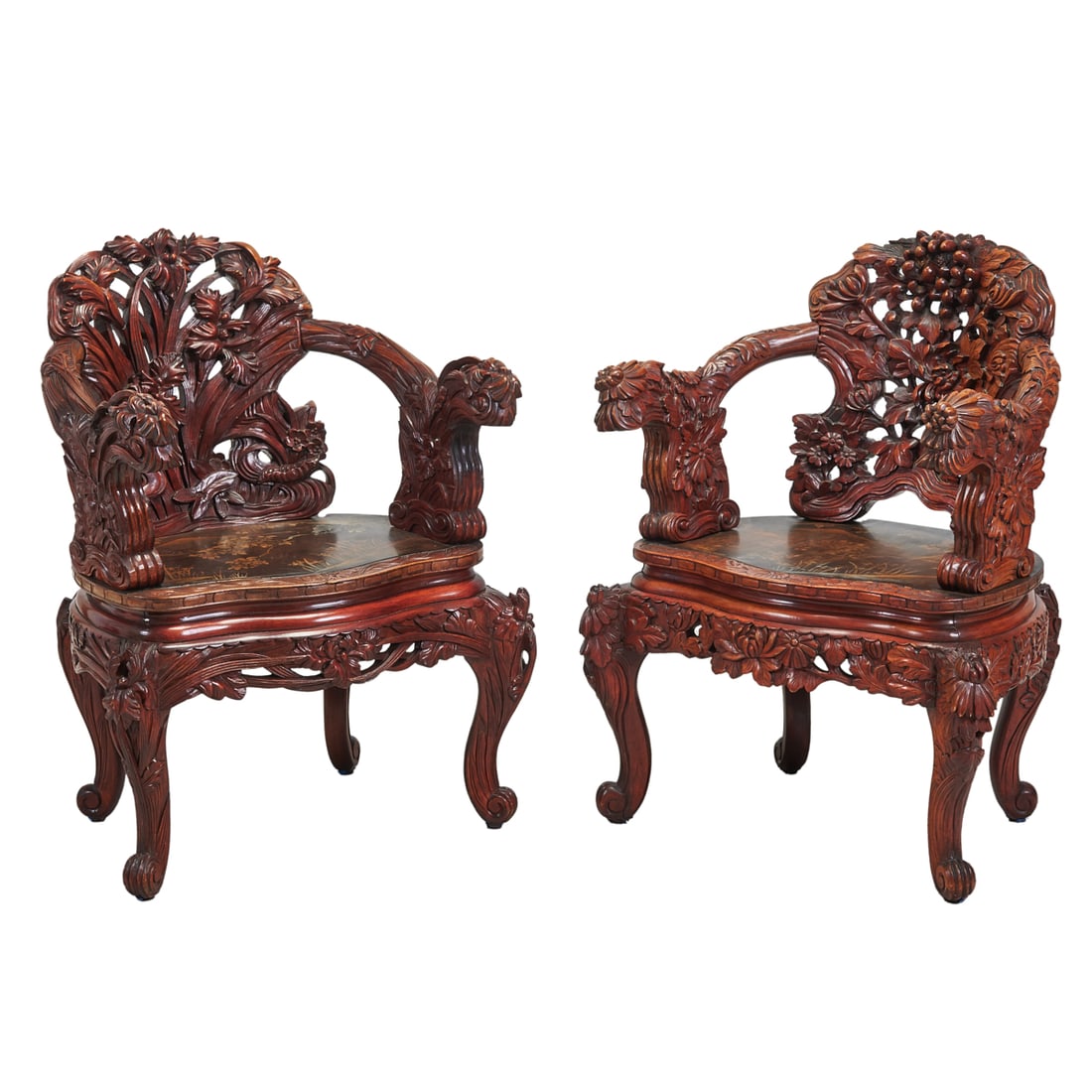 A Pair of Japanese Carved and Lacquered Armchairs: A Pair of Japanese Carved and Lacquered Armchairs. Each back distinctively decorate with floral and prunus carvings, the arched armrest connecting with dragon mask terminals, the seated surface decora