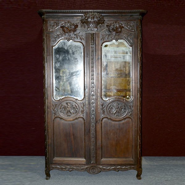 French Provincial Mirrored Marriage Armoire: French Provincial Ebonized Marriage Armoire, the outswept cornice moulding with a egg and dart border, over a leafy carved frieze centered by a floral arrangement in a basket, above a pair of shaped a