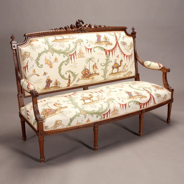 Louis XVI Style Canape: Louis XVI Style Canape, The hunting trophy carved back with a hat, horn and rifle centering a wreath flanked by twin floral lengths, an upholstered back, and out scrolled padded arms on acanthus carve