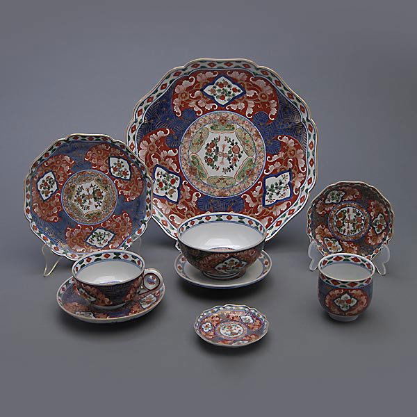A Japanese Enamel-Decorated Dining Set: A Japanese Enamel-Decorated Dining Set, of Imari style with Chinese character marks to each base, including eighteen dinner plates, five tea cups, six saucers, six wine cups, six bread plates, six con