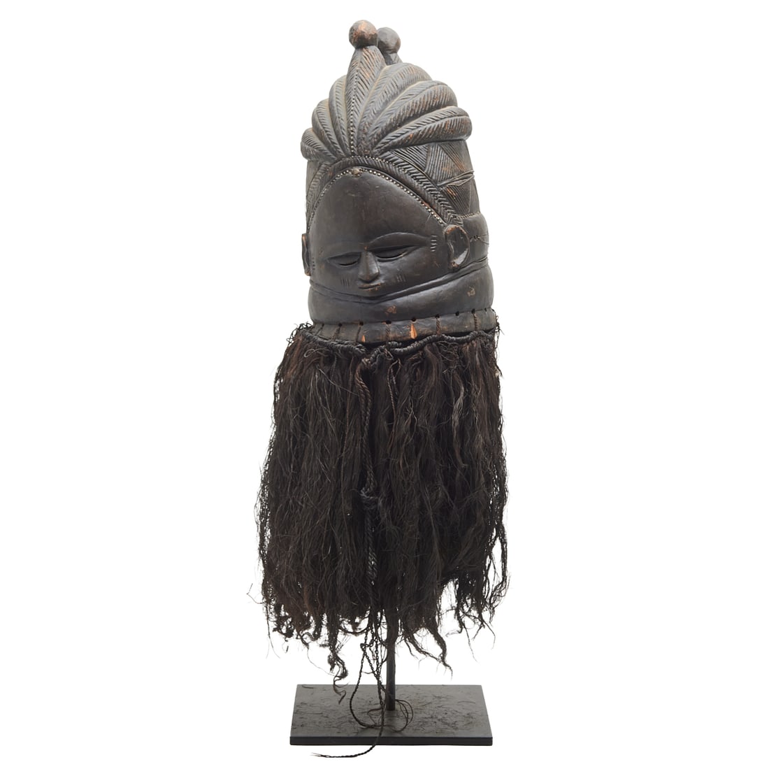 African Mende Carved Wood Helmet Mask: African Mende Carved Wood Helmet Mask. Ebonized carved wood helmet with metal "inlay" trim, mask hung with long animal hair, on later black metal stand. {Approximate dimensions n