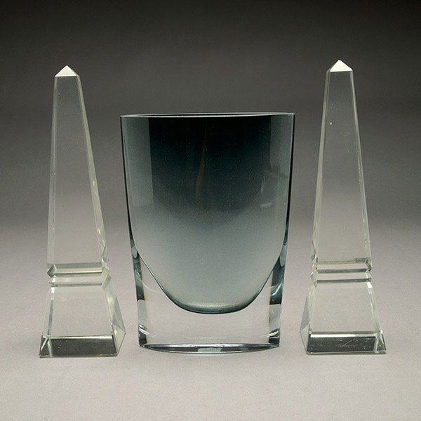 Two Glass Obelisks with Grey Glass Vase.: Two Glass Obelisks with Grey Glass Vase. Each obelisk measures approximately 10 inches in height by 2 1/2 inches at the base. The grey vase measures approximately 8 1/2 x 6 inches.