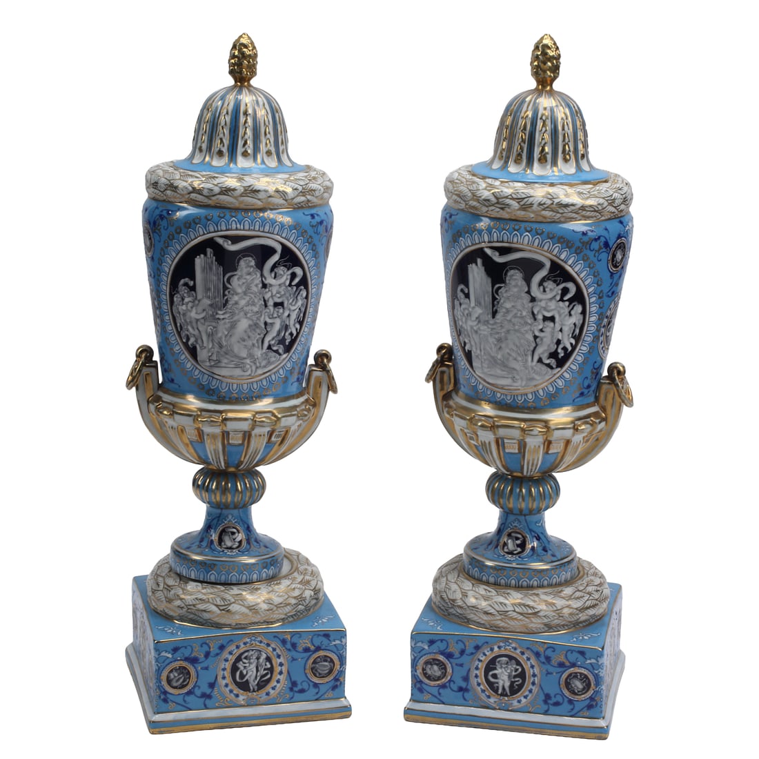 Pair of Minton Style Blue Ground Porcelain Urns: Pair of Minton Style Blue Ground Porcelain Urns, on square plinth bases, with'domed covers with gilt'pineapple top knobs, with classical style figures reserved on dark blue grounds and gilt lion's hea