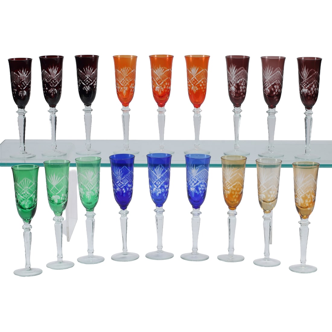 Lot of Eighteen Colored Cut Crystal Goblets: Lot of Eighteen Colored Cut Crystal Goblets.' Comprising three blue, three green, three red, three purple, three amber, and three orange goblets with clear cut design to cups and clear stems. {Approxi