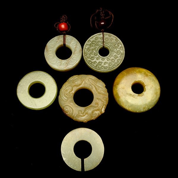 A Group of Six Jade 'Bi 'Disks: A Group of Six Jade 'Bi 'Disks, three carved with either scroll patterns or chilong dragons {Largest Diameter: 2 1/8 inches (5.4 cm)} [Chips, old losses, abrasions]