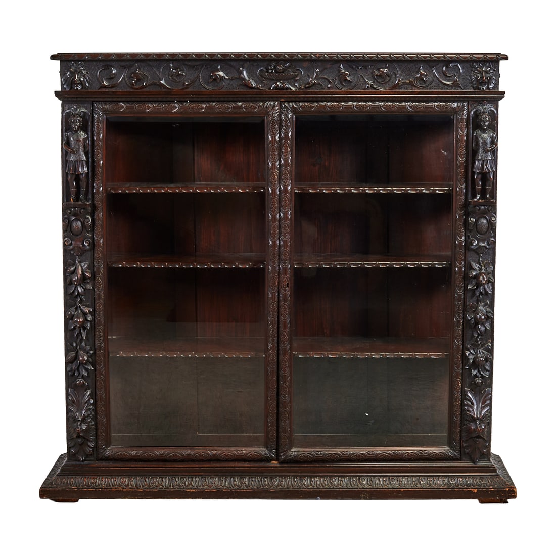 Renaissance Revival Oak Bookcase: Renaissance Revival Oak Bookcase, carved with figures and masks masks, scrolling foliage and flower heads and geometric motifs, the whole body stained dark brown.{Approximate dimensions: 57" high x 61