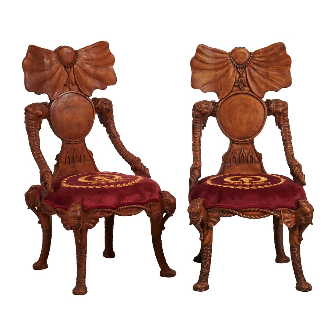 Pair of Black Forest Style Novelty Fantasy Chairs: Pair of Black Forest Style Novelty Fantasy Chairs, the splats carved in the manner of elephant ears, and the arms in the manner of elephant trunks, with elephant heads in high relief to knees above fl