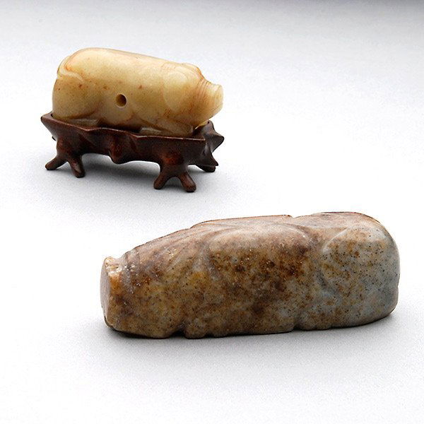 Two Jade Figures of Pigs, Han Dynasty: Two Jade Figures of Pigs, Each stylized animal carved with deep slashed grooves delineating the head and limbs, one with a hole pierced through the body. Han Dynasty, Longest: 3 1/4 inches (8.3 cm), P