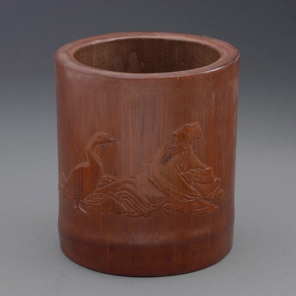 A Bamboo Brush Pot: A Bamboo Brush Pot, The cylindrical container carved in relief to depict the story of Wang Xizhi, the famous calligrapher, studying a goose, reversed by an incised inscription describing the scene and