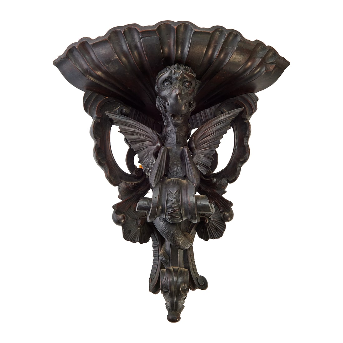 Victorian Carved Blackened Oak Figural Bracket: Victorian Carved Blackened Oak Figural Bracket, the triangular top overcast above the dramatic grotesque mask, carved in high relief. {Approximate dimensions: 24" H. x 19" W. x 18" D.}