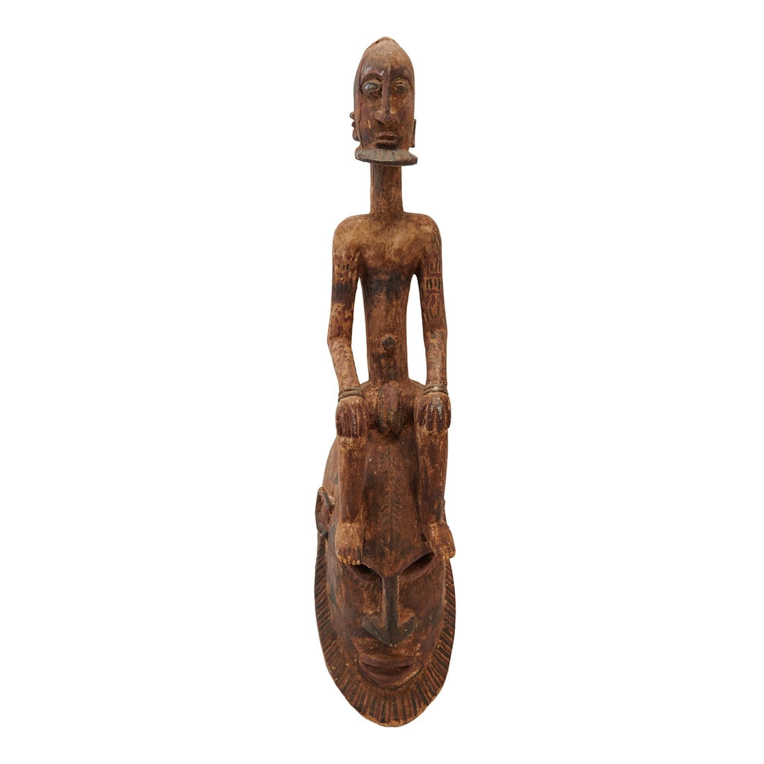 West African Figure Mask: West African Figure Mask, the wood carved male figure seated at rest on elongated oval male mask, painted in brown, black, red.{Approximate dimensions: 28 1/2" long x 6 1/2" wide x 7" deep.}.