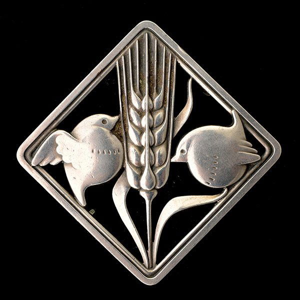 GEORG JENSEN BIRD WITH WHEAT BROOCH.: GEORG JENSEN STERLING SILVER BIRD WITH WHEAT BROOCH. The brooch #250, designed by Arno Malinowski, features two birds on a shaft of wheat in an open work square frame and measuring approximately 1 1/2