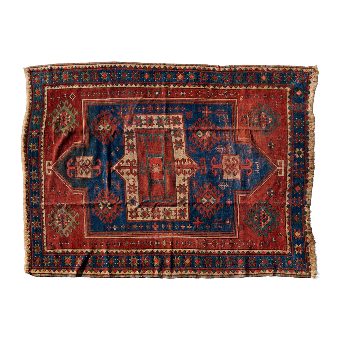 Caucasian Kazak Inscribed Rug: Caucasian Kazak Inscribed Rug, woven in wool with red center field, and within the field, a blue and off white pointed medallion, with guls and stylized geometric foliate motifs.{Approximate