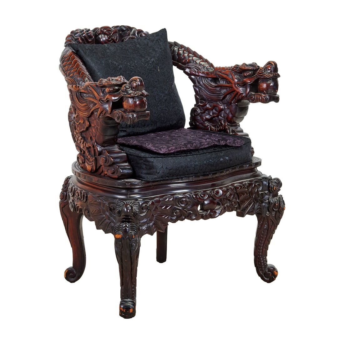 Japanese Export Carved Wood Dragon Armchair: Japanese Export Carved Wood Dragon Armchair.The chair of rounded form, the frame extensively carved with intertwined dragons, the arms terminating in dragon heads each grasping a pearl, the back and s