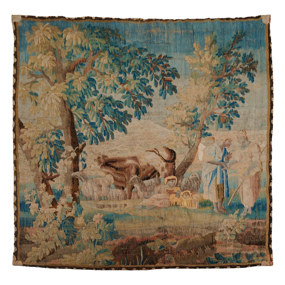 Flemish Biblical Tapestry: Flemish Biblical Tapestry, wool with natural dyes, the subject a verdant, woodedscene centering milkmaids near cows, with merchants to the side, within a shaped border, the whole mounted onto a faun c
