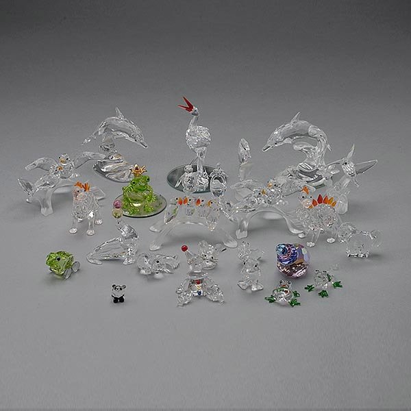 22 Swarovski Crystal Figures and 3 Glass Frogs: Twenty Two Swarovski Crystal Figures: Comprising two dolphins; five figural groups of birds; two dinosaurs; clown; circus clown; seashell; seahorse; eight miniature animals; and a basket; together wit
