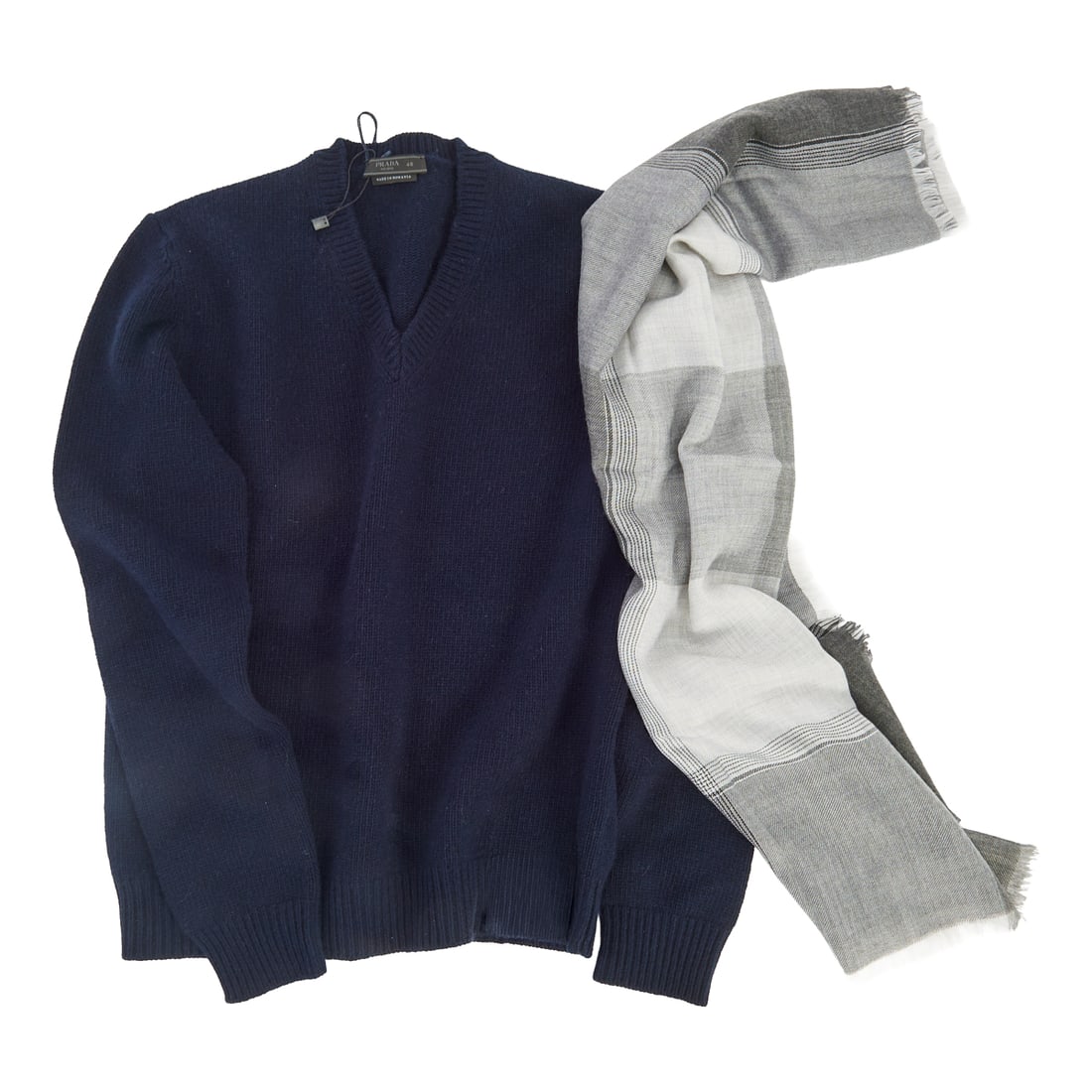 Prada Cashmere Sweater and Loro Piana Scarf. Comprising blackv-neck Prada sweater in size 48, and: Prada Cashmere Sweater and Loro Piana Scarf. Comprising blackv-neck Prada sweater in size 48, and Piana light weight wool scarf in large plaid print in greys with intersectingstriped square to border.