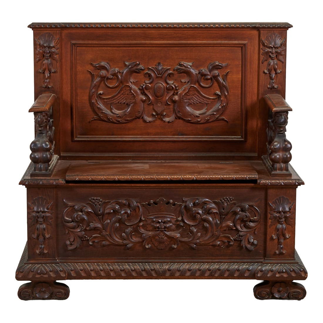 Renaissance Revival Carved Hall Bench, chip carved crest to back, over bas relief applique of: Renaissance Revival Carved Hall Bench, chip carved crest to back, over bas relief applique of griffons with shield, en facent, the flat, straight armrests over additional female griffons, the seat wit