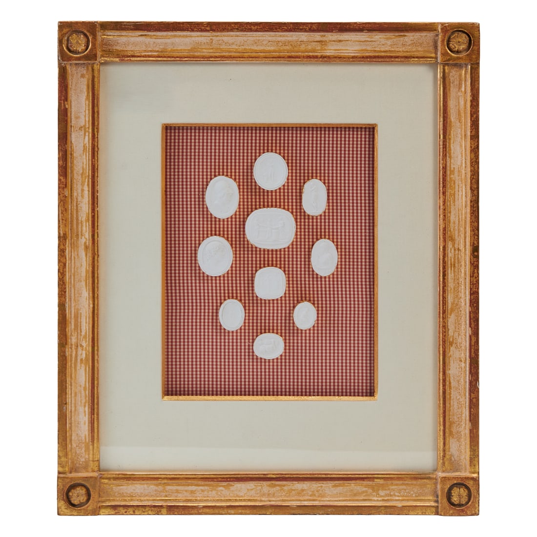 Four Framed Plaster Medallions After the Antique, mounted onto gingham backing, under white mats,: Four Framed Plaster Medallions After the Antique, mounted onto gingham backing, under white mats, within gitlwood frames.{Approximate dimensions: 13" H.x 10 " W. x 2" D.}.