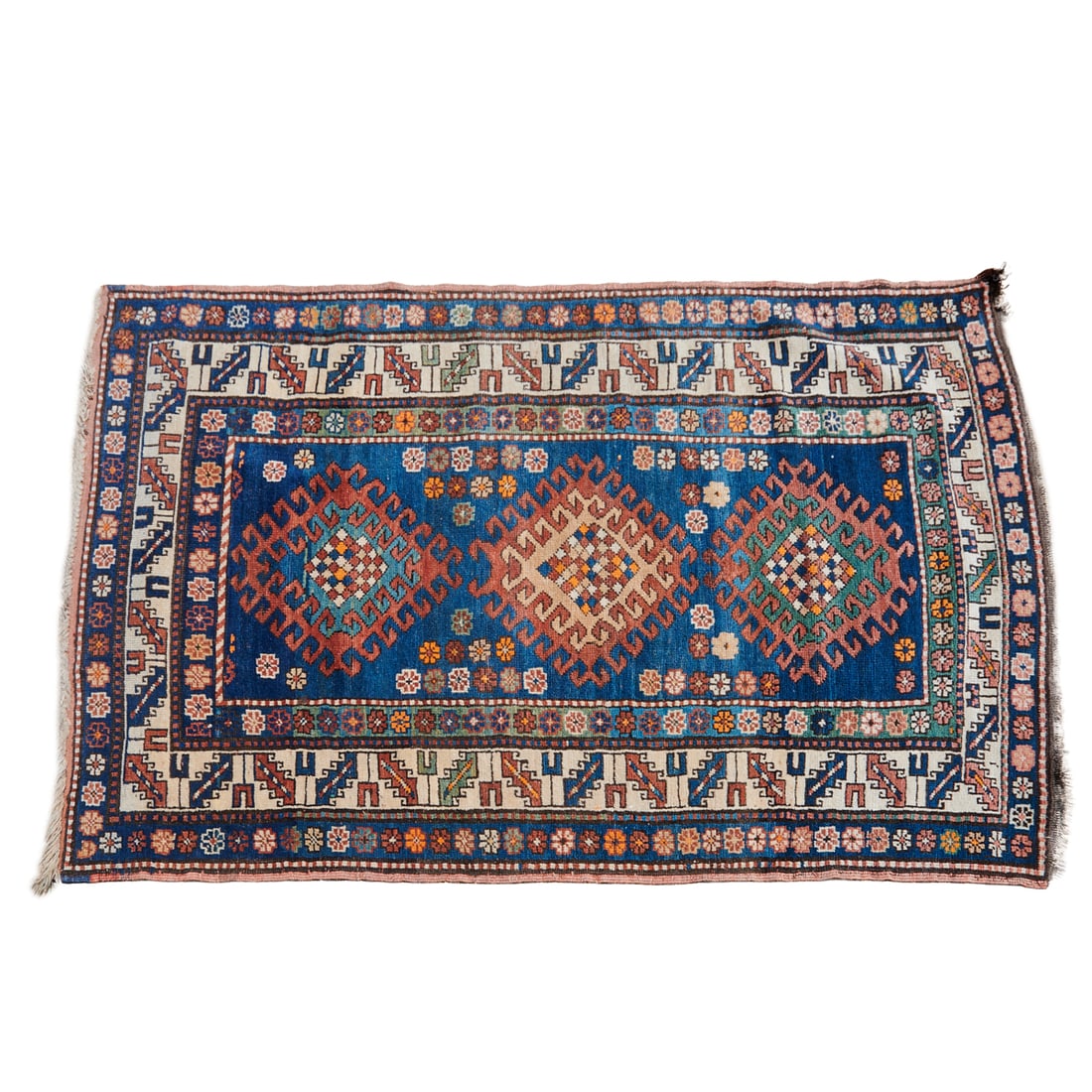 Caucasian Kazak Wool Rug, woven in ombre shades of blue, orange ocher and off whitewith three: Caucasian Kazak Wool Rug, woven in ombre shades of blue, orange ocher and off whitewith three central diamond form guls, with flowerhead designs to sides, the primary border of off white, with sytlize