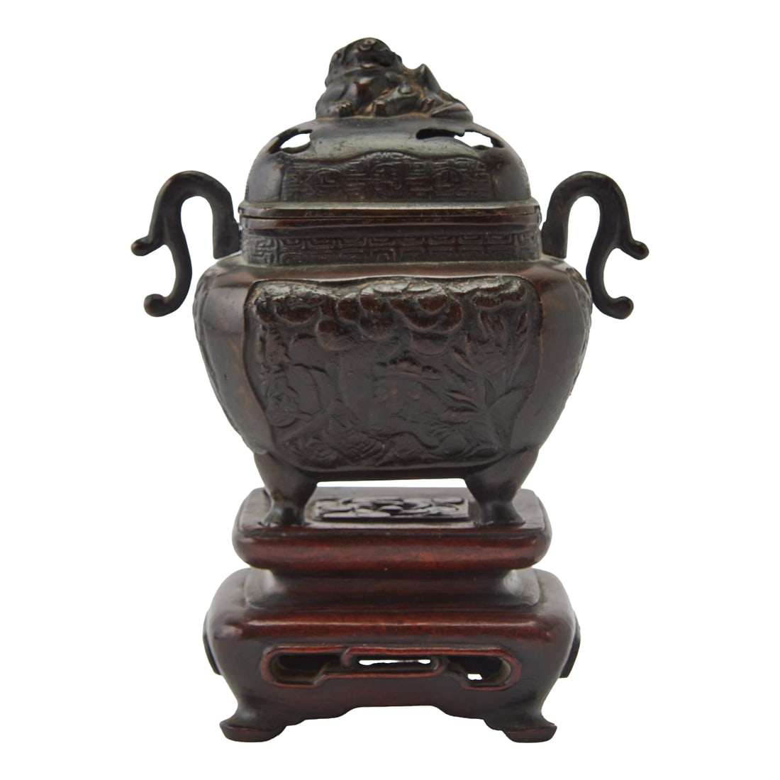 An Archaistic Bronze Incense Burner with a Hardwood StandQing Dynasty to Republic PeriodThe bronze: An Archaistic Bronze Incense Burner with a Hardwood StandQing Dynasty to Republic PeriodThe bronze incense burner of compressed rectangular form, raised on four tapering legs and flanked by a pair of 