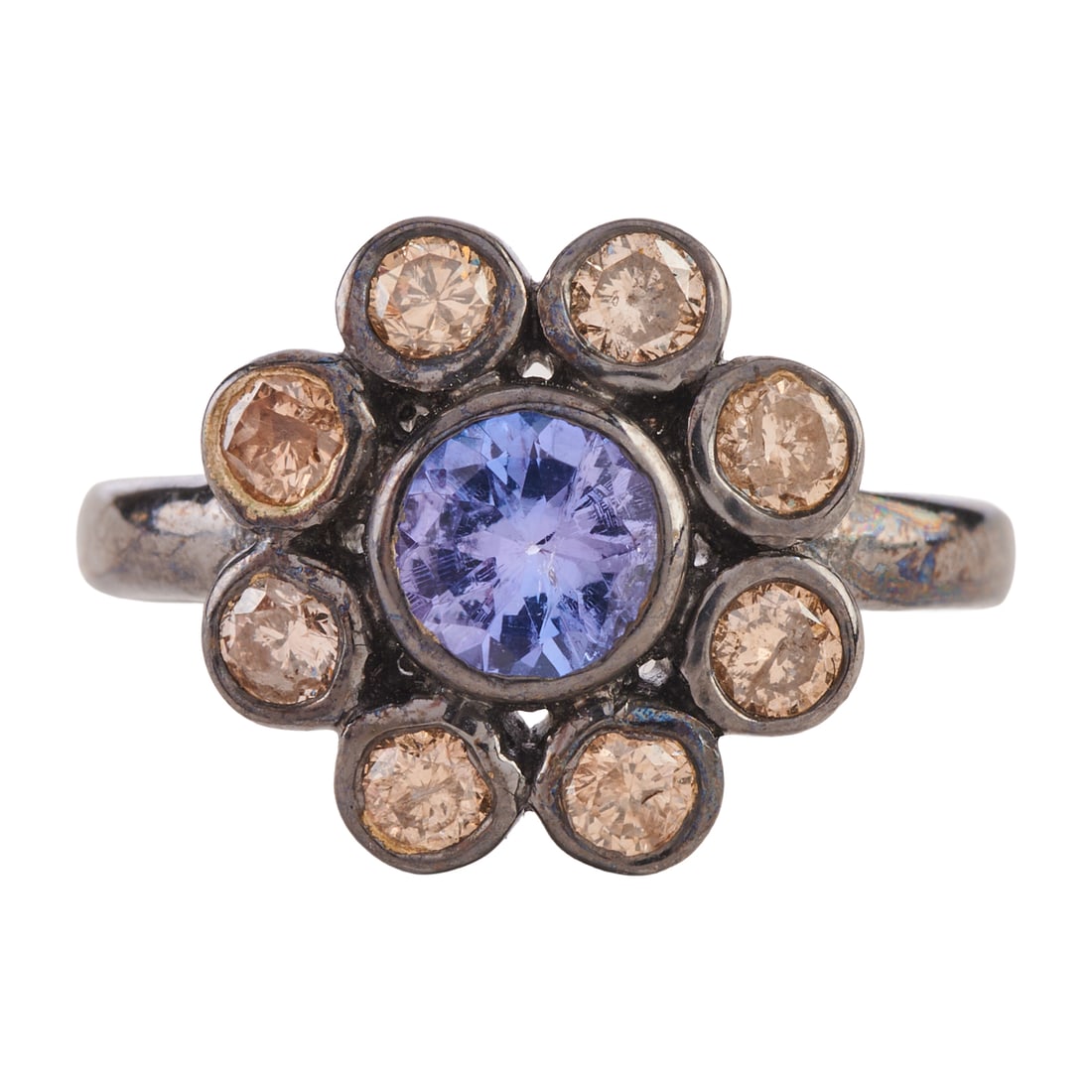 Tanzanite, Diamond, Oxidized Silver Ring: Tanzanite, Diamond, Oxidized Silver Ring. Centering one round-cut tanzanite measuring approximately 5 mm, surrounded by eight full-cut brown diamonds weighing a total of approximately 0.50 cttw., set 