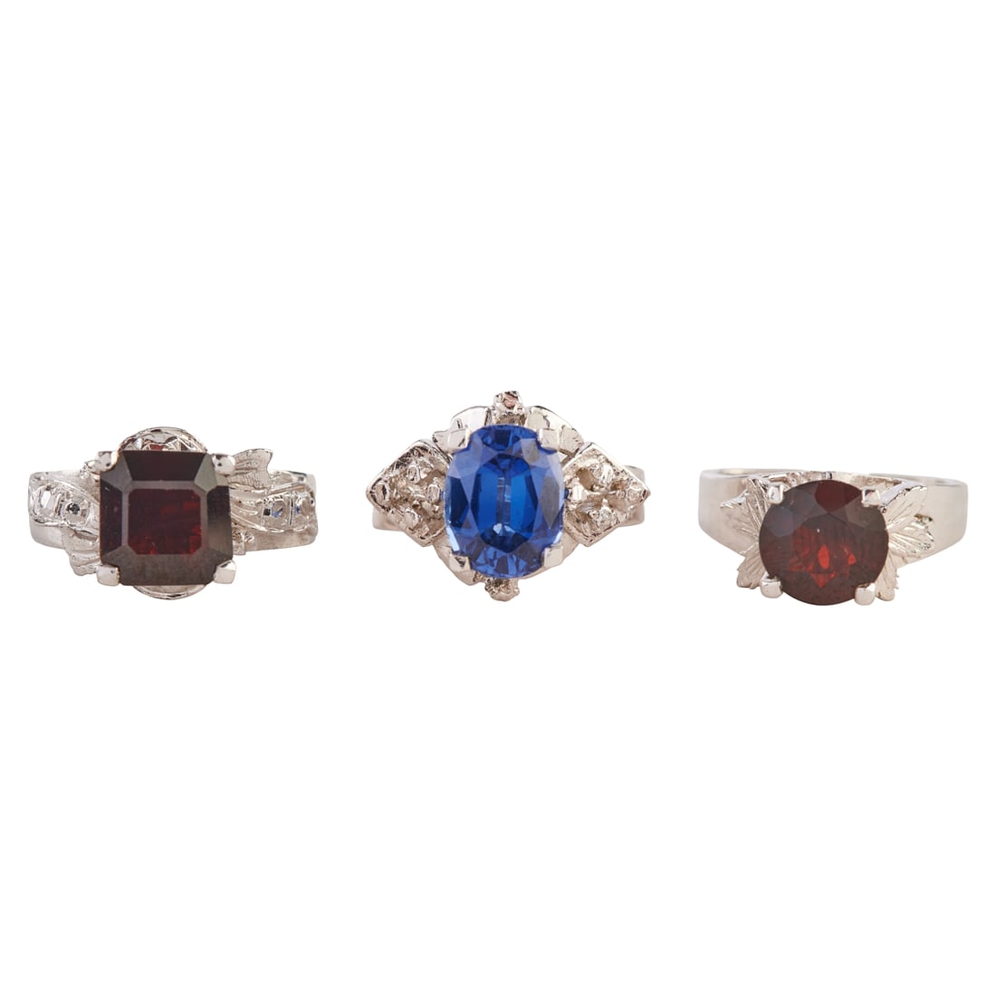 Collection of Three Garnet, Sapphire, Rhodium-Plated Rings: Collection of Three Garnet, Sapphire, Rhodium-Plated Rings. Including one oval-cut sapphire, rhodium-plate ring, size 5 1/2; one round-cut garnet, rhodium-plate ring, size 4 together with one
