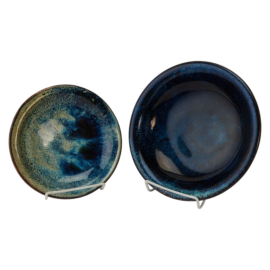 Two Qing Dynasty Shiwan Ware Dishes: Two Qing Dynasty Shiwan Ware Dishes.Each heavily potted stoneware dish is covered overall with a lustrous dark blue glaze, mottled and streaked with pale blue and creamy-white tones. The glaze display