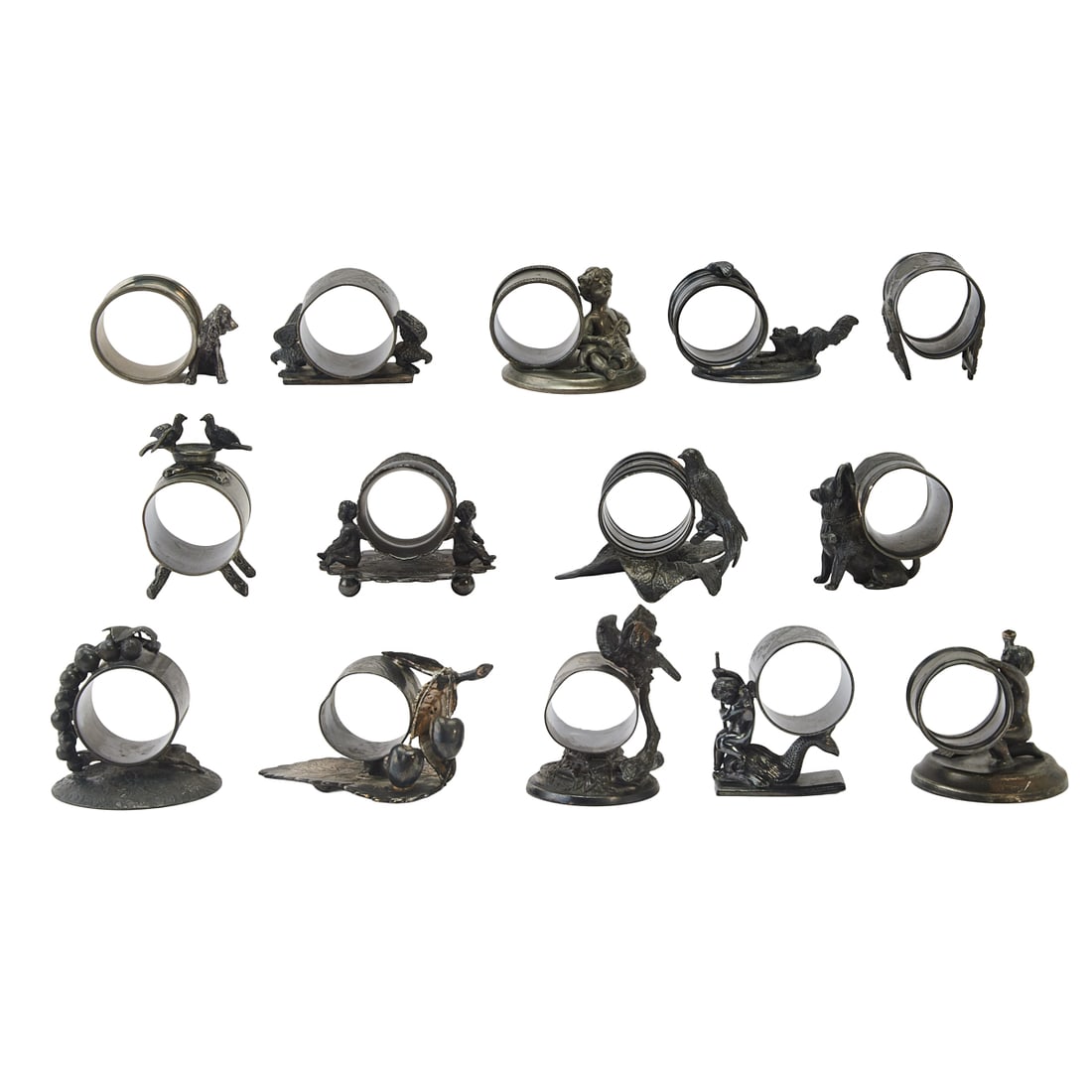 Fourteen Victorian Silverplate Napkin Rings: Fourteen Victorian Silverplate Napkin Rings, comprising whimsical figural, fruit and foliate embelllished napkin rings on bases, some figures include birds, putti, dogs, grapes, and others. Various