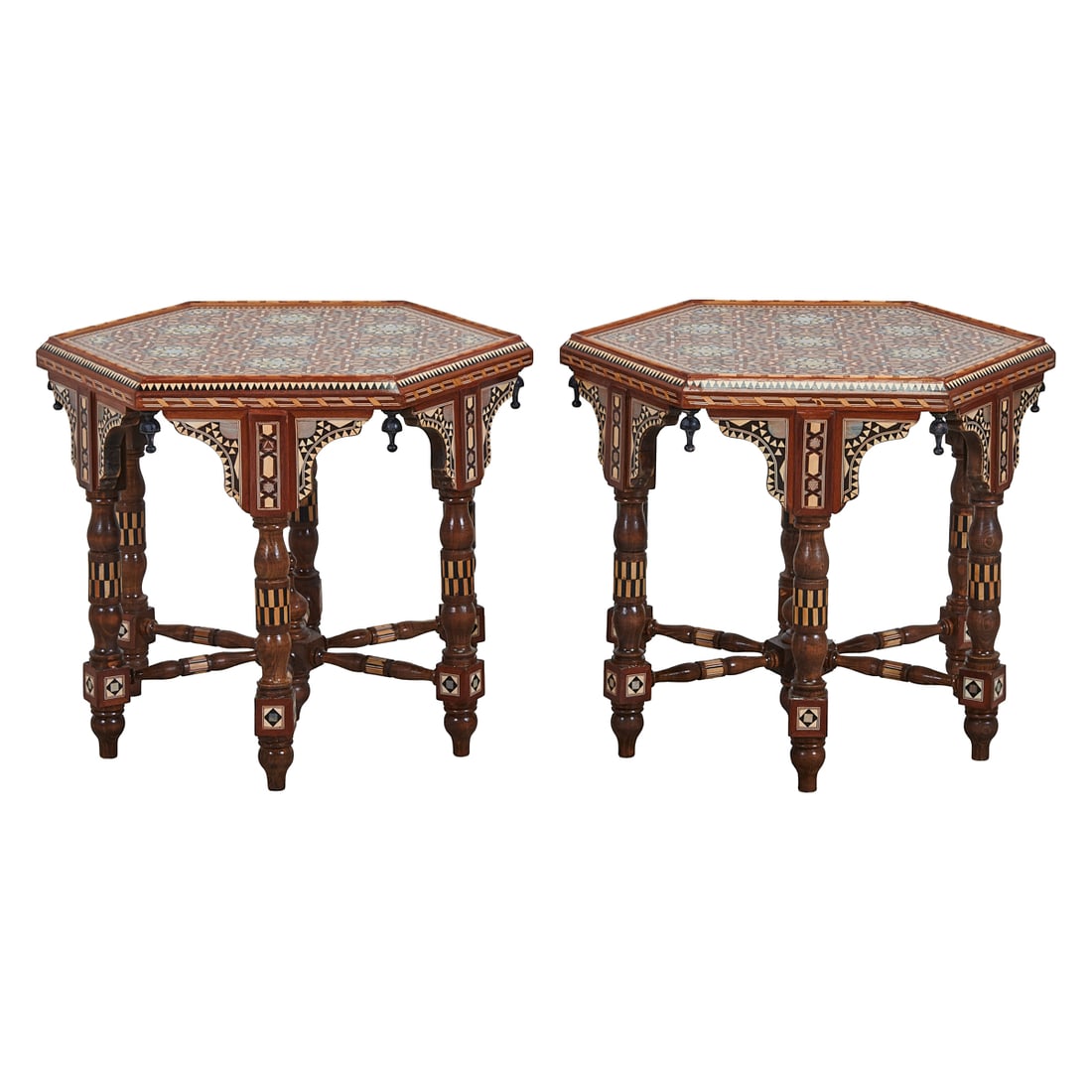 Pair of Moorish Style Inlaid Hexagonal Low Tables: Pair of Moorish Style;Inlaid Hexagonal Low Tables, the tops overcast above carved and inlaid elements, on and between the turned legs, conjoined by X stretchers.{Approximate dimensions: 20" H. x 24"
