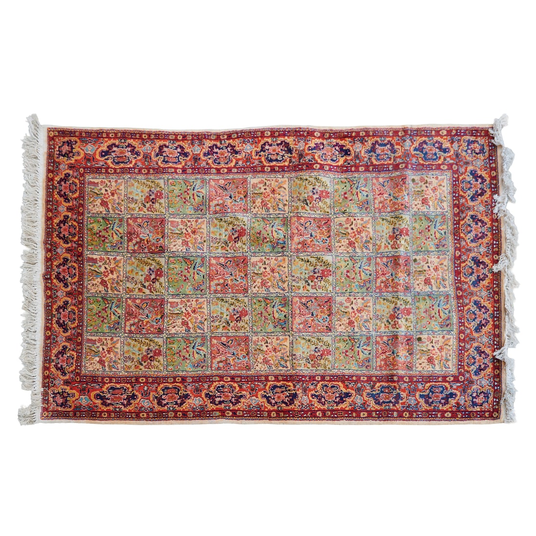 Persian Qum Rug: Persian Qum Rug, woven in wool and cotton, with floral and foliate designs in squares, in pastel hues, the red primary border woven with shaped reserves in deep blue, with addition foliate motifs,