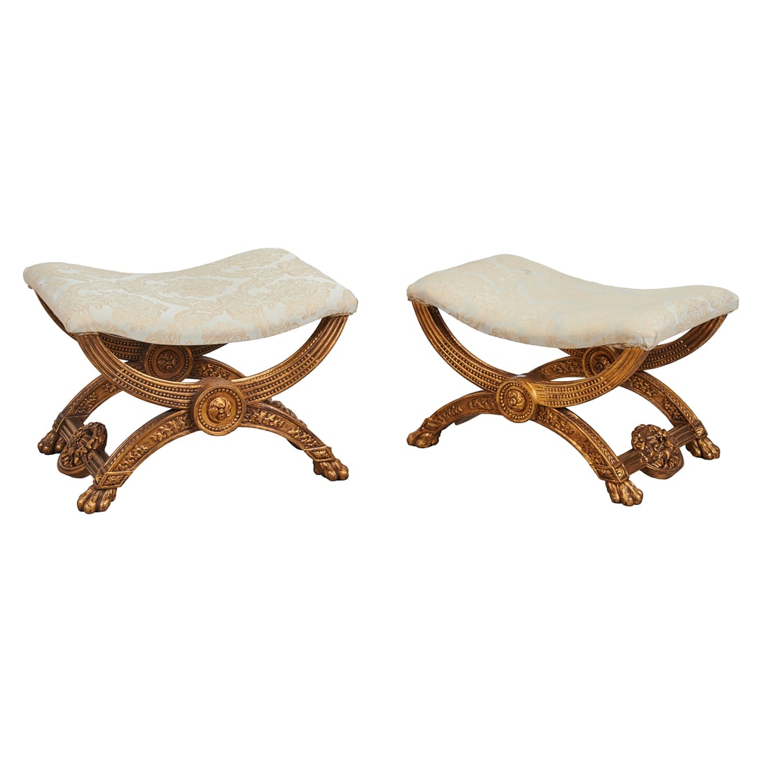 Pair of Neoclassical Style Wood Carved and Upholstered Curule Stools: Pair of Neoclassical Style Wood Carved and Upholstered Curule Stools, the incurvate;seats;upholstered in cream damask with pale yellow crewelwork, over carved, giltwood bases.{Approximate dimensions: 