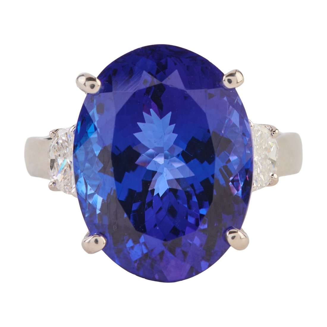 Rhapsody Tanzanite, Diamond, Platinum Ring: Rhapsody Tanzanite, Diamond, Platinum Ring. Featuring one oval-cut tanzanite weighing approximately 10.98 cts., flanked by two half moon-cut diamonds weighing a total of approximately 0.35 cttw., set
