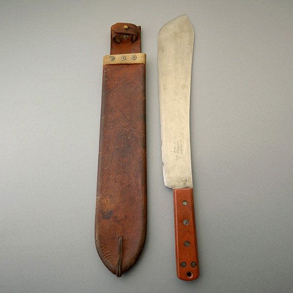 Military Machete by K.S. & B: Military Machete by Kitchin, Sheffield, with Broad Arrow Mark and Leather Scabbar 14 3/4-inch long blade with Kitchin Ltd. marking and broad arrow with date 1952. Rust color composition grip panels, o