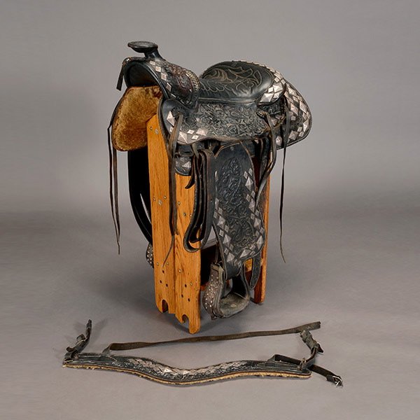 Vintage Parade Saddle with Silver Diamonds: Vintage Parade Saddle, a square skirted saddle, fender, a breast collar, back cinch and stirrups allover with leafy poppy design, fitted with an engraved silver diamond border and "leather" conchos, u