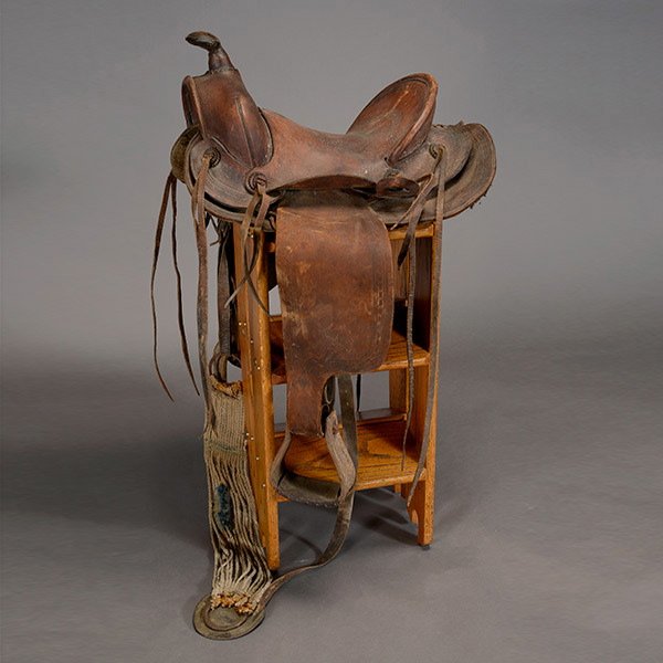 Antique Keyston Bros. Saddle: Antique Keyston Bros. Saddle, San Francisco, a skirted saddle, fender, and stirrups, decorated with interlocking chain banding, fitted with "leather" conchos, silver metal plaque "Made In San Francisc