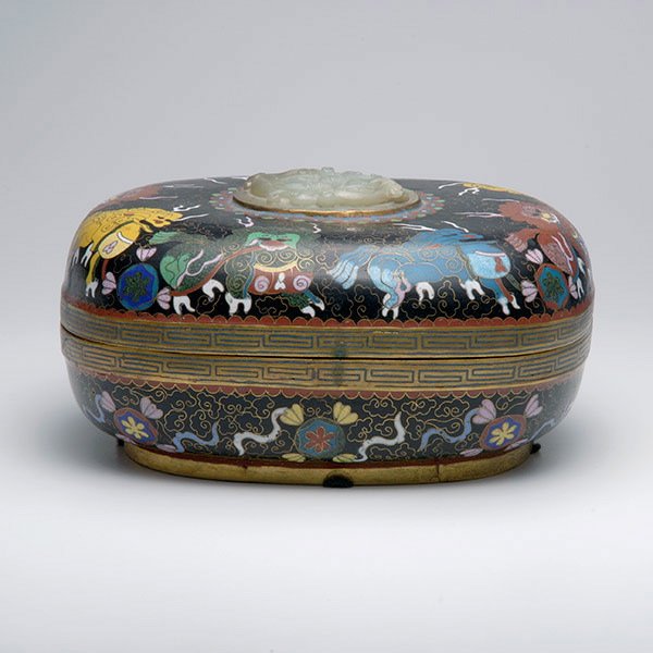 A Cloisonné Enamel Lidded Box, Early 20th Century: A Cloisonné Enamel Lidded Box, The lid decorated with eight lions and surmounted by a jade plaque of a pair of chilong dragons, all on a black ground. Early 20th Century, Length: 9 inches (22.8 cm) [