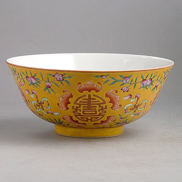 A Famille Rose Yellow-Ground Birthday Bowl: A Famille Rose Yellow-Ground Birthday Bowl, decorated with longevity symbols, bats and peaches {Diameter: 8 1/2 inches (21.6 cm)} [Crazing]