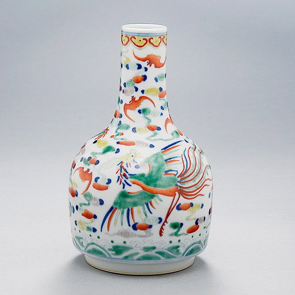 A Wucai Bottle Vase: A Wucai Bottle Vase, painted with a phoenix and dragon, a mark to the base {Height: 7 inches (17.8 cm)}