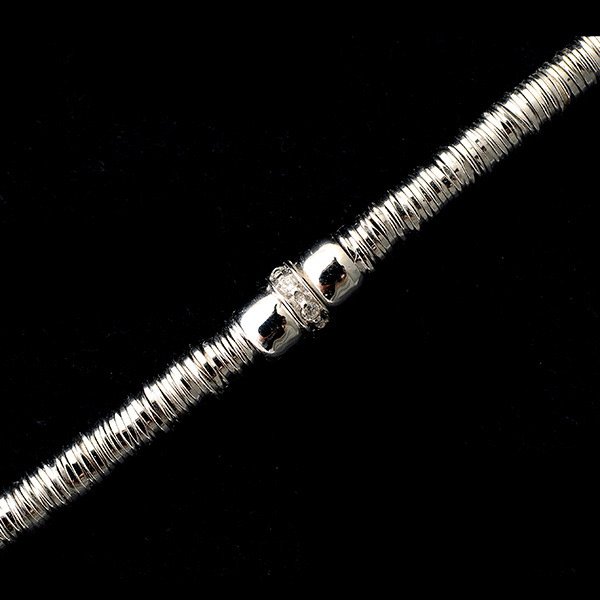 DIAMOND, 18K WHITE GOLD BRACELET.: DIAMOND, 18K WHITE GOLD BRACELET. Centering six full-cut diamonds weighing a total of approximately 0.06 cttw., set in an 18k white gold wire coil articulated mounting, completed by a tongue and groov