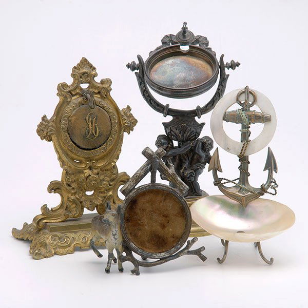 Three Watch Stands:: Three Watch Stands: One Black Forest cold painted; one gilt bronze pocket stand; and one mixed metal with amorini {Height 6 3/4 inches}; together with a mother of pearl salt with anchor (4)