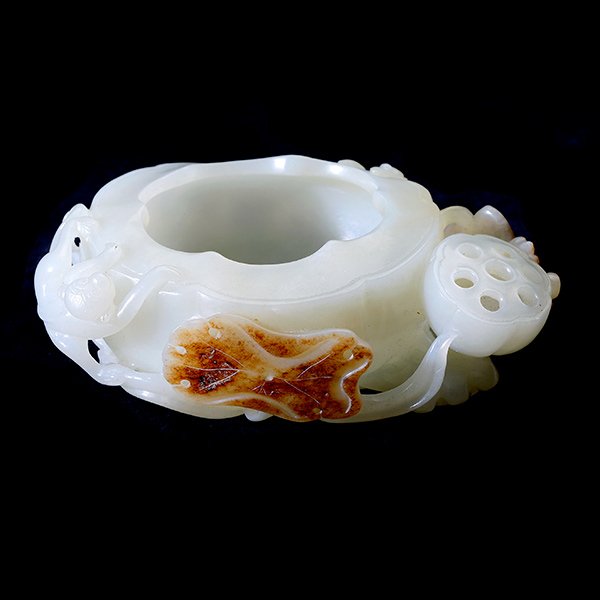 White Jade Lotus-Shaped Brush Washer, Qing Dynasty: A White Jade Lotus-Shaped Brush Washer, Carved from a stone of even white hue with sveral areas of russet inclusion, the oval vessel well hollowed and decorated with two monkeys, a dragon fly and a bu