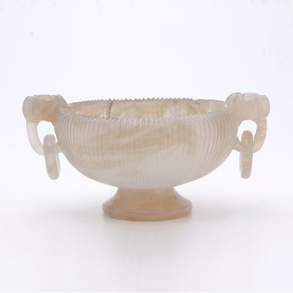 A Mughal Style Agate Stem Cup: A Mughal Style Agate Stem Cup, The exterior with ribs of shells encircled outside, with a pair of floriform handles tangling loose rings, raised on a flaring foot. Width: 4 inches (10. 2 cm) [Chips. T