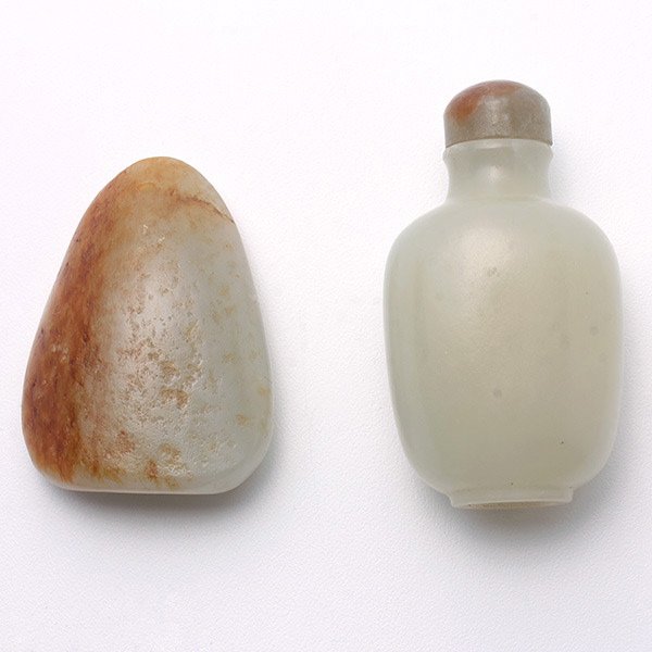 Two White Jade Carvings, Qing Dynasty: Two White Jade Carvings, The first a snuff bottle with a concave mouth and recessed base. with a jade stopper; the second a pebble-form toggle with russet inclusions. Qing Dynasty, Height: 2 1/4 inche