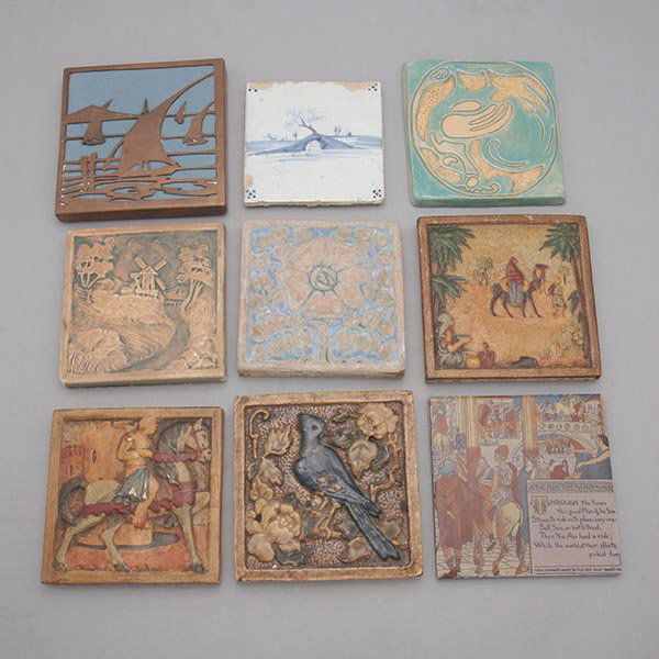 Nine Arts & Crafts Faience Tiles and Trivets: Nine Arts & Crafts Faience Tiles and Trivets: Including three California Art Tiles; one Mosaic "The Man That Pleased None"; one Rookwood with copper overlay; one Claycraft with bird; one Bachelor; and